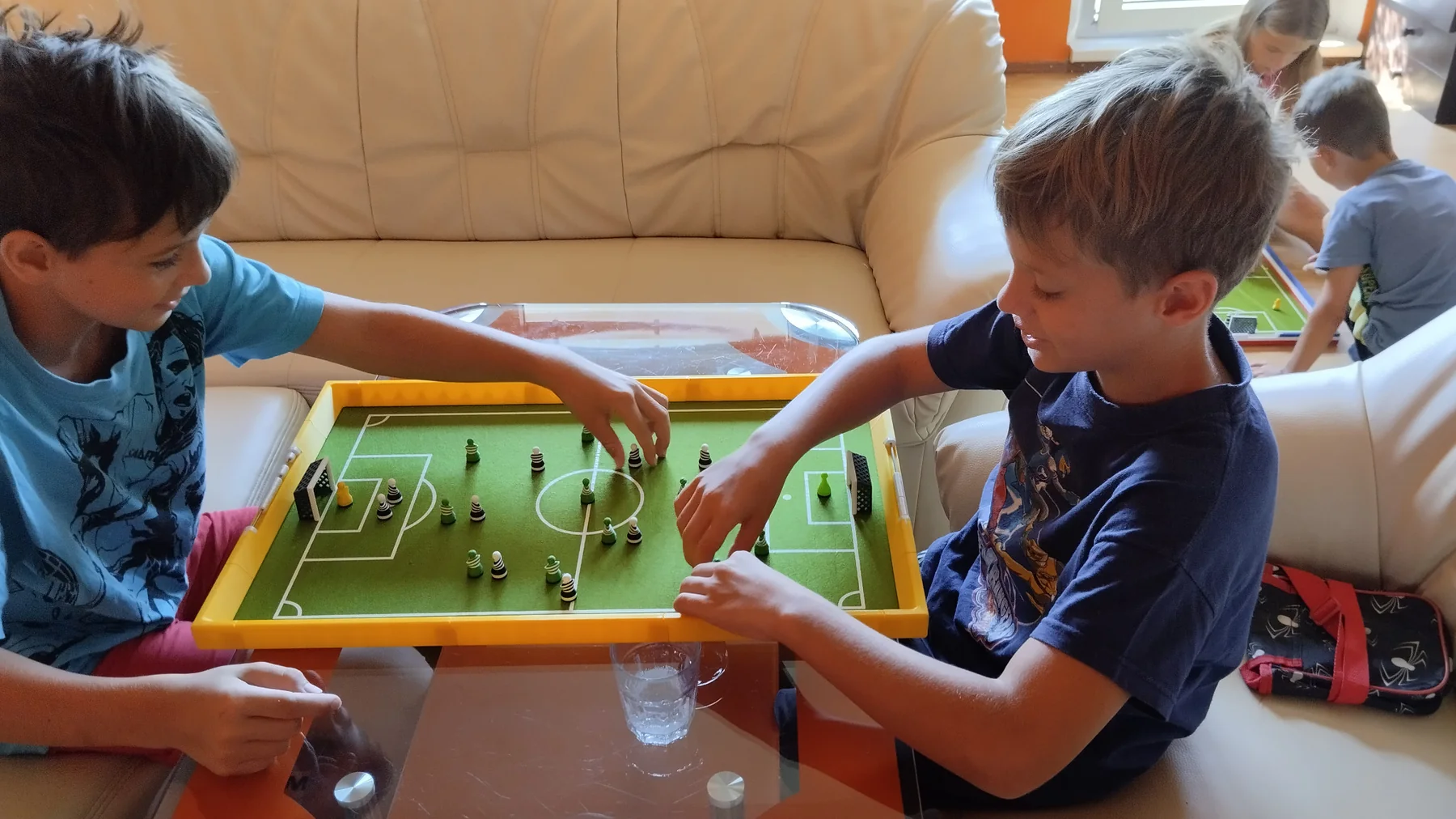 Two children playing Footballec in the living room